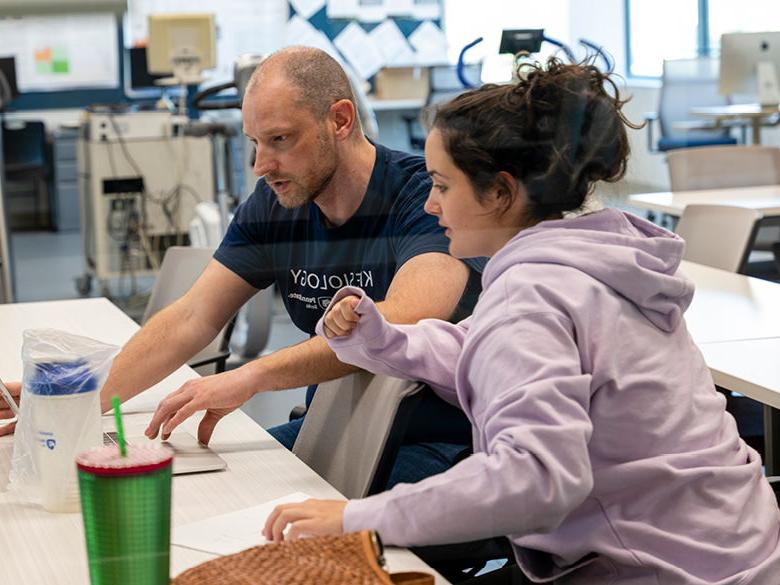 Kinesiology faculty member reviews data on laptop with student