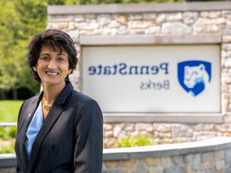 Photo of Chancellor Radha Pyati in front of Penn State Berks entrance sign